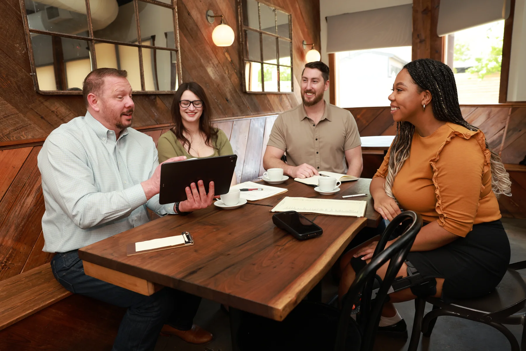 The Manucci Financial team meeting around a restaurant table.